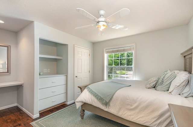 118 Frisco Dr, Houghton Lake, MI 48629 - bedroom featuring dark wood-style floors, built in desk, and ceiling fan