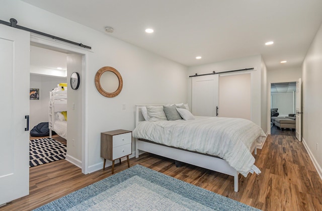118 Frisco Dr, Houghton Lake, MI 48629 - bedroom featuring a barn door, wood finished floors, and recessed lighting