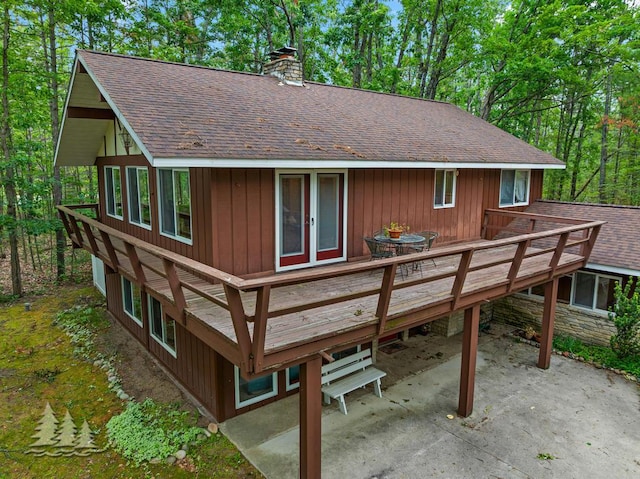 2801 Cobb Rd, Lewiston, MI 49756 - rear view of property featuring roof with shingles, a chimney, a patio area, and a wooden deck