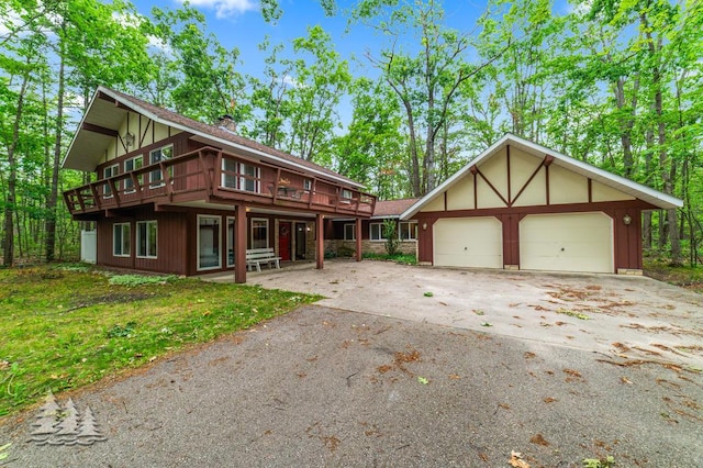 2801 Cobb Rd, Lewiston, MI 49756 - view of front of house featuring driveway, a chimney, a deck, and a garage