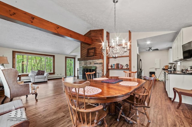 2801 Cobb Rd, Lewiston, MI 49756 - dining room with a textured ceiling, a large fireplace, dark wood-style flooring, ceiling fan, and a chandelier