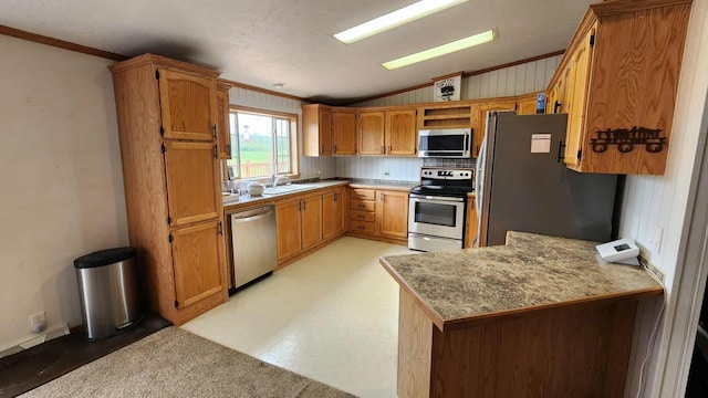 15135 M-32, Lachine, MI 49753 - kitchen with appliances with stainless steel finishes, vaulted ceiling, crown molding, brown cabinetry, and a peninsula