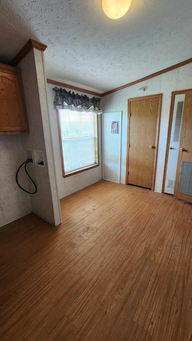 15135 M-32, Lachine, MI 49753 - unfurnished dining area featuring crown molding, wood finished floors, and a textured ceiling
