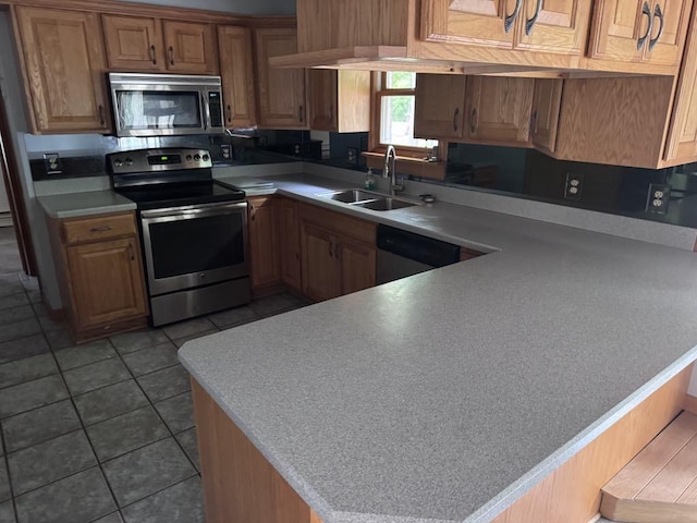 3011 Piper Rd, Alpena, MI 49707 - kitchen featuring stainless steel appliances, light countertops, tile patterned flooring, and a peninsula