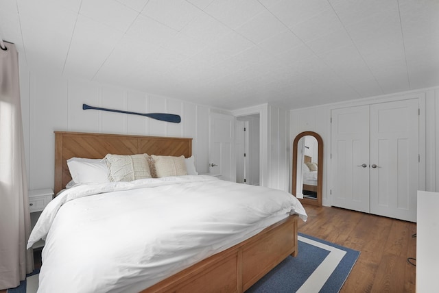 802 Houghton View Dr, Prudenville, MI 48651 - bedroom featuring a decorative wall and wood finished floors