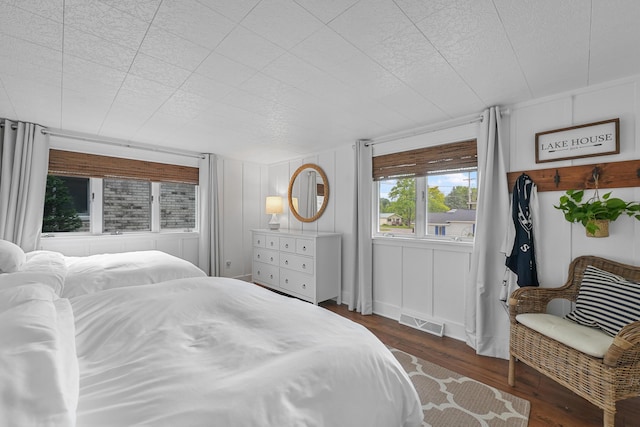 802 Houghton View Dr, Prudenville, MI 48651 - bedroom with dark wood-style floors and a decorative wall