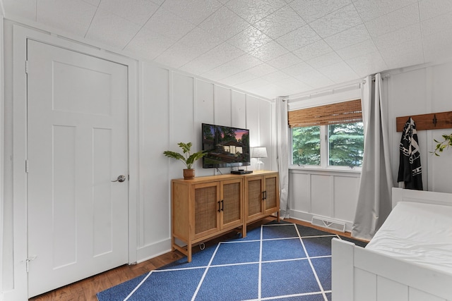 802 Houghton View Dr, Prudenville, MI 48651 - bedroom with dark wood-style flooring and a decorative wall