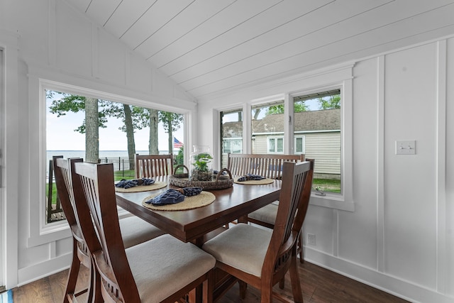 802 Houghton View Dr, Prudenville, MI 48651 - dining space with a decorative wall, vaulted ceiling, dark wood finished floors, plenty of natural light, and a water view