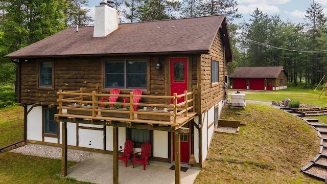 6612 Old Vanderbilt Rd, Vanderbilt, MI 49795 - back of property featuring a patio area, a chimney, a deck, and roof with shingles