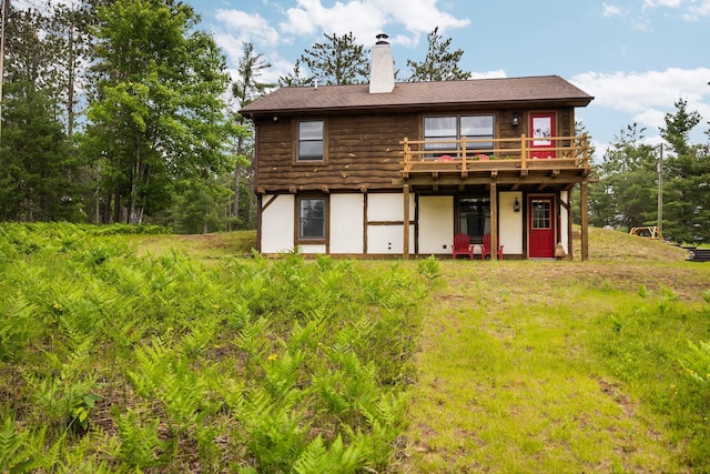 6612 Old Vanderbilt Rd, Vanderbilt, MI 49795 - back of property featuring a chimney, a wooden deck, and stucco siding