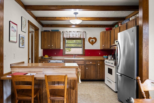 6612 Old Vanderbilt Rd, Vanderbilt, MI 49795 - kitchen with freestanding refrigerator, white stove, beamed ceiling, brown cabinetry, and a peninsula