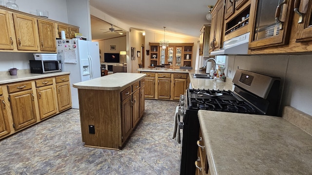 7717 Weiss Rd, Alpena, MI 49707 - kitchen with stainless steel appliances, a kitchen island, ceiling fan, brown cabinets, and decorative light fixtures