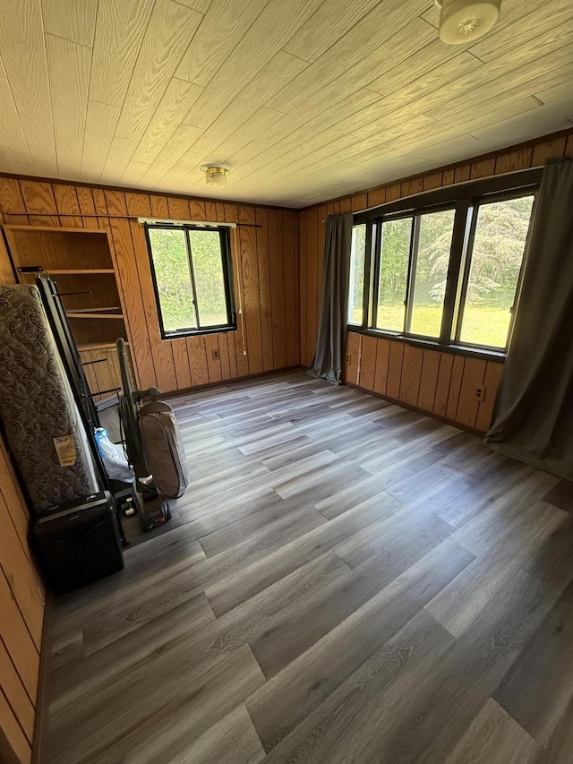 2493 S Horseshoe Trl, Grayling, MI 49738 - unfurnished living room with wooden walls, wood finished floors, healthy amount of natural light, and wooden ceiling