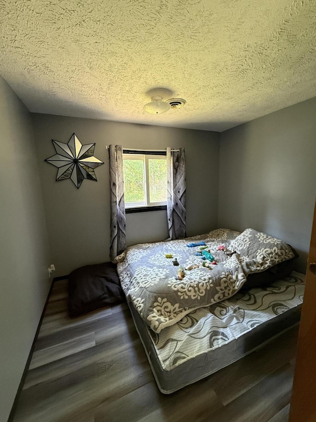 2493 S Horseshoe Trl, Grayling, MI 49738 - bedroom with wood finished floors and a textured ceiling