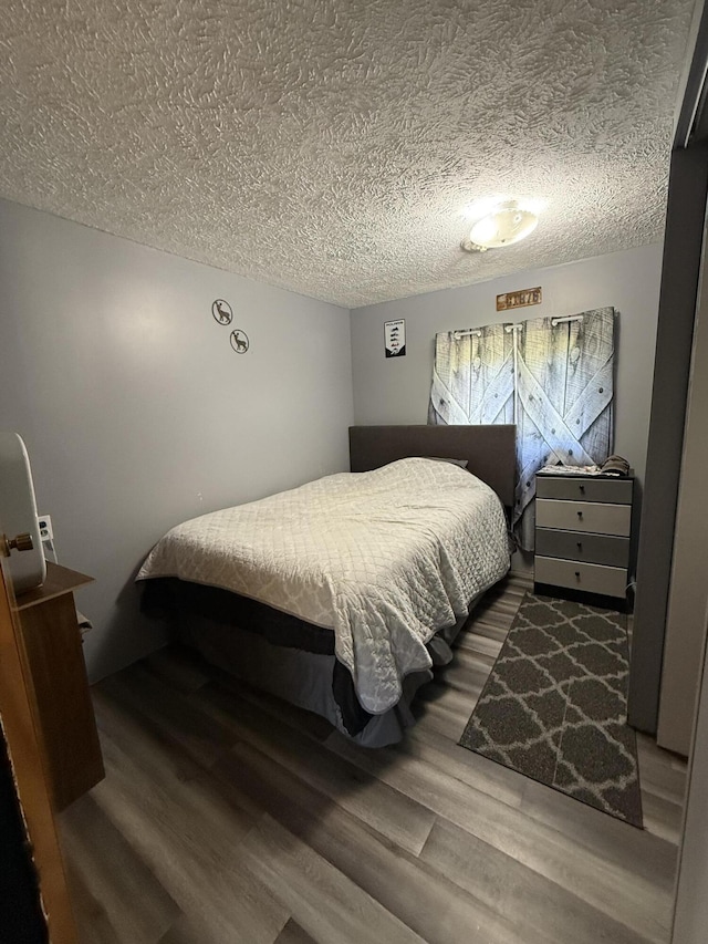 2493 S Horseshoe Trl, Grayling, MI 49738 - bedroom with wood finished floors and a textured ceiling
