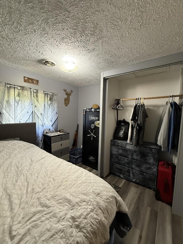 2493 S Horseshoe Trl, Grayling, MI 49738 - bedroom featuring wood finished floors, a textured ceiling, and a closet
