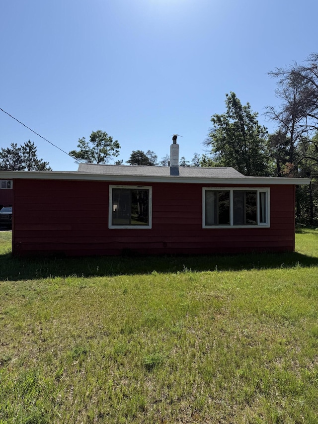 2493 S Horseshoe Trl, Grayling, MI 49738 - view of side of property with a lawn and a chimney