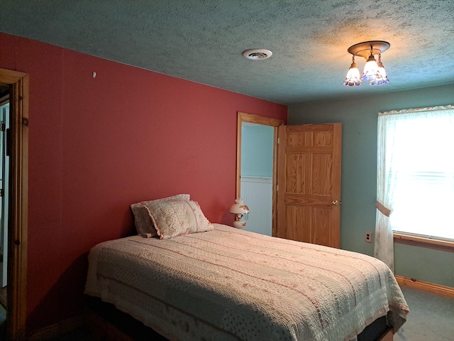 4160 S Vaughn Lake Rd, Glennie, MI 48737 - bedroom featuring multiple windows, carpet floors, and a textured ceiling