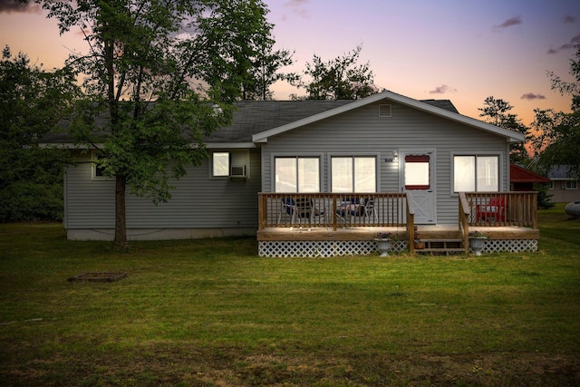 2731 Gregory St, Lewiston, MI 49756 - back of house at dusk featuring a lawn, a wooden deck, cooling unit, and a shingled roof