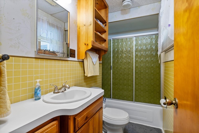 2731 Gregory St, Lewiston, MI 49756 - bathroom featuring vanity, bath / shower combo with glass door, tile walls, and a wainscoted wall