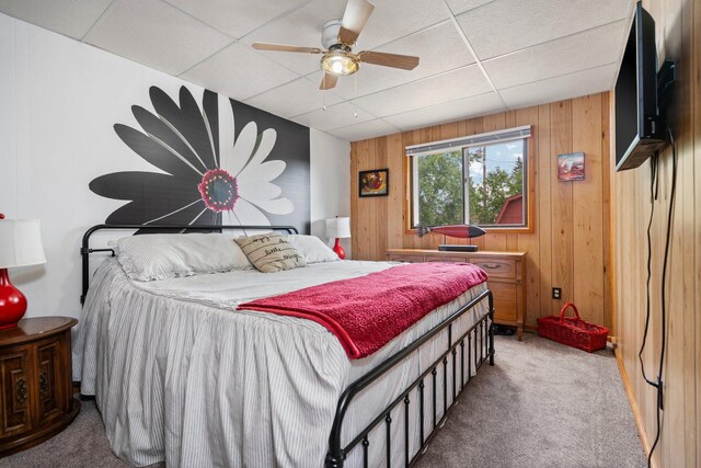 2731 Gregory St, Lewiston, MI 49756 - carpeted bedroom with a paneled ceiling, wood walls, and ceiling fan