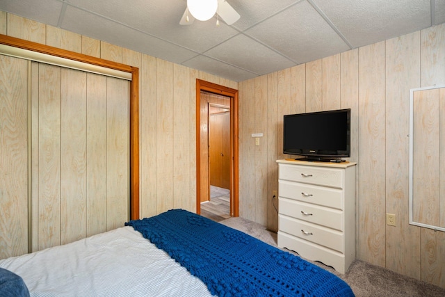 2731 Gregory St, Lewiston, MI 49756 - bedroom with wooden walls, carpet flooring, a closet, and a ceiling fan