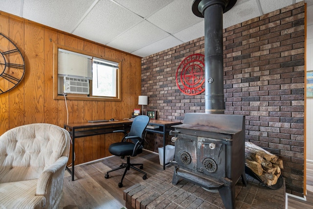 2731 Gregory St, Lewiston, MI 49756 - office space featuring cooling unit, wood finished floors, a wood stove, wood walls, and brick wall