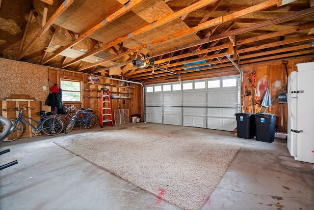 2731 Gregory St, Lewiston, MI 49756 - garage with a garage door opener and freestanding refrigerator