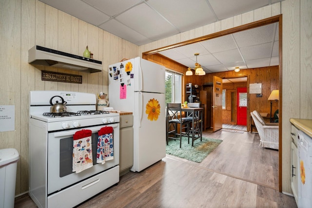 2731 Gregory St, Lewiston, MI 49756 - kitchen with white appliances, custom exhaust hood, wood walls, a drop ceiling, and wood finished floors