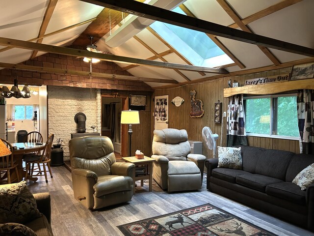 16831 Moores Landing Rd, Lachine, MI 49753 - living room with a skylight, wooden walls, plenty of natural light, wood finished floors, and beam ceiling