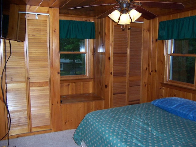 409 Marvin Rd, Roscommon, MI 48653 - carpeted bedroom featuring wood walls, wood ceiling, and multiple closets