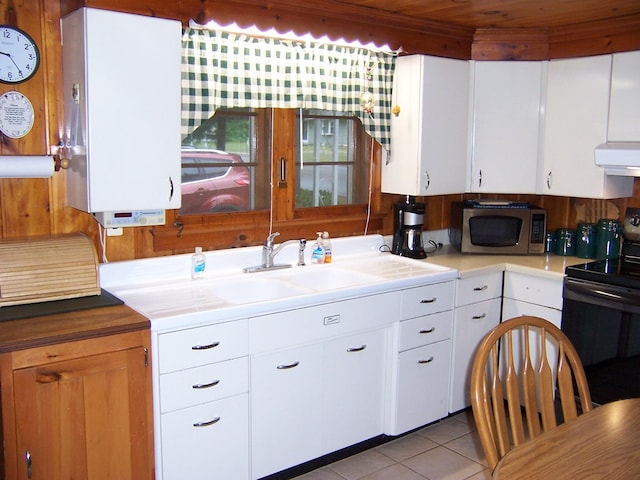 409 Marvin Rd, Roscommon, MI 48653 - kitchen featuring stainless steel microwave, electric range, extractor fan, tile patterned floors, and light countertops