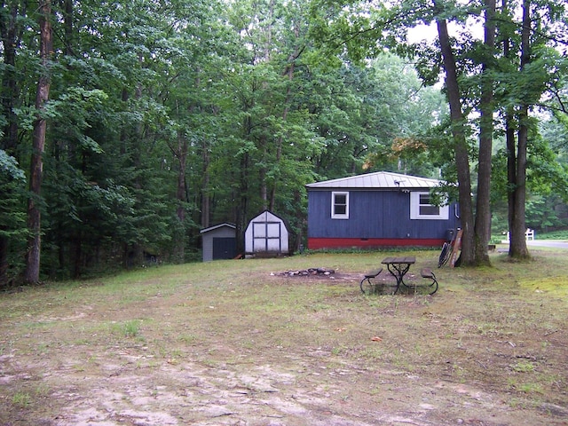 409 Marvin Rd, Roscommon, MI 48653 - view of yard featuring a storage unit and a view of trees