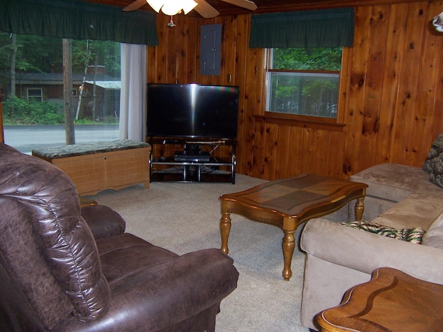 409 Marvin Rd, Roscommon, MI 48653 - carpeted living area featuring wooden walls, healthy amount of natural light, ceiling fan, and electric panel
