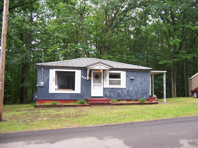 409 Marvin Rd, Roscommon, MI 48653 - view of front facade with a metal roof and a front lawn