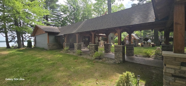 1161 Lagoon St, Lewiston, MI 49756 - view of front of home with a front lawn, a shingled roof, and a water view