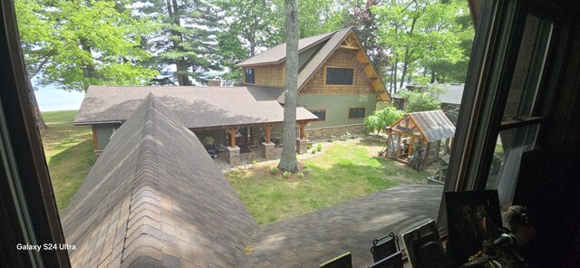 1161 Lagoon St, Lewiston, MI 49756 - rear view of house with a yard, a greenhouse, an outbuilding, and roof with shingles