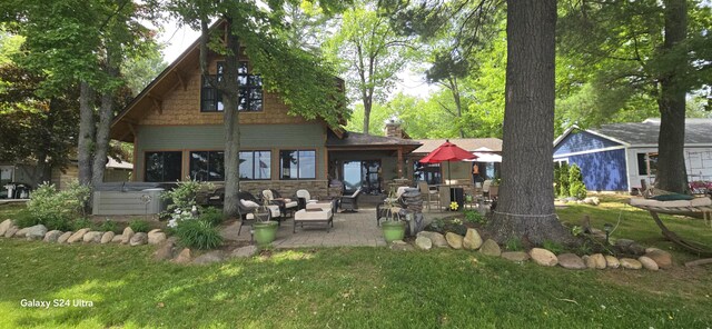 1161 Lagoon St, Lewiston, MI 49756 - rear view of house featuring a hot tub, a patio area, a yard, and a chimney