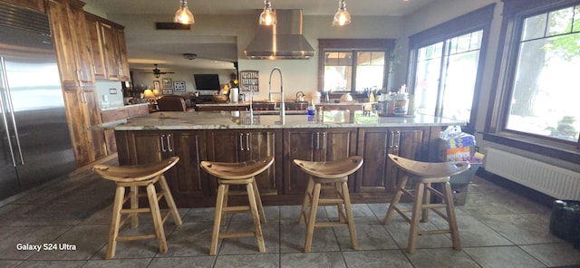 1161 Lagoon St, Lewiston, MI 49756 - bar featuring radiator, stainless steel built in fridge, wall chimney range hood, and healthy amount of natural light