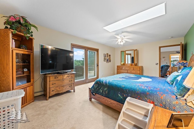 881 N Red Oak Rd, Lewiston, MI 49756 - bedroom with access to exterior, a baseboard radiator, a skylight, light carpet, and a ceiling fan