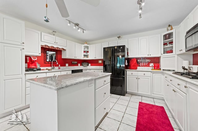 881 N Red Oak Rd, Lewiston, MI 49756 - kitchen with black appliances, track lighting, a center island, and light tile patterned floors