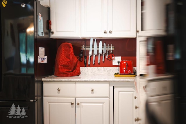 881 N Red Oak Rd, Lewiston, MI 49756 - kitchen with freestanding refrigerator, white cabinets, and light countertops