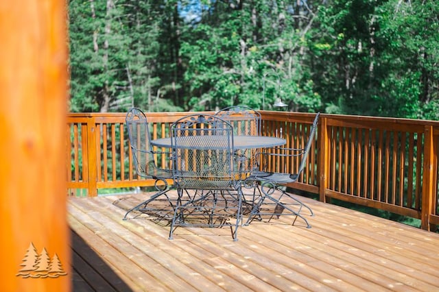 881 N Red Oak Rd, Lewiston, MI 49756 - wooden deck with outdoor dining space and view of wooded area