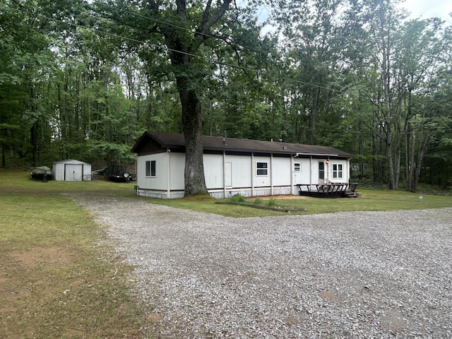 15939 Hiawatha Trl, Atlanta, MI 49709 - view of front of house featuring a shed, a front yard, and gravel driveway