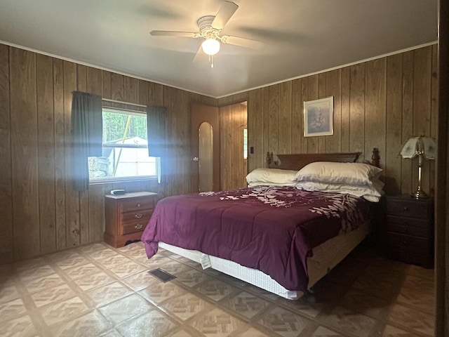 15939 Hiawatha Trl, Atlanta, MI 49709 - bedroom with wooden walls, arched walkways, light flooring, and ceiling fan