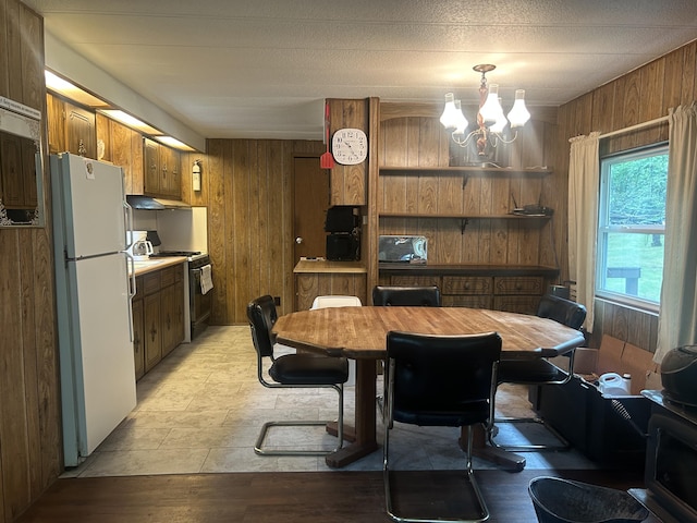 15939 Hiawatha Trl, Atlanta, MI 49709 - dining space featuring wooden walls, a chandelier, and light wood-style flooring