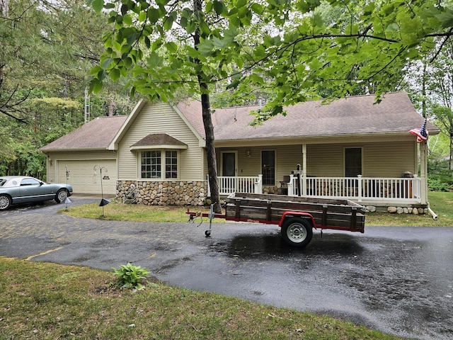 14911 Kings Ln, Ocqueoc, MI 49759 - ranch-style home featuring covered porch, driveway, an attached garage, stone siding, and a chimney