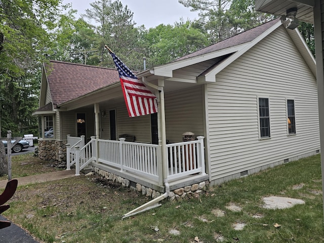 14911 Kings Ln, Ocqueoc, MI 49759 - view of side of home featuring a porch, crawl space, and a shingled roof
