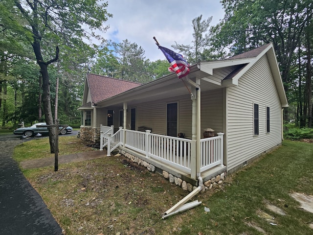 14911 Kings Ln, Ocqueoc, MI 49759 - view of side of home with a porch, roof with shingles, and crawl space