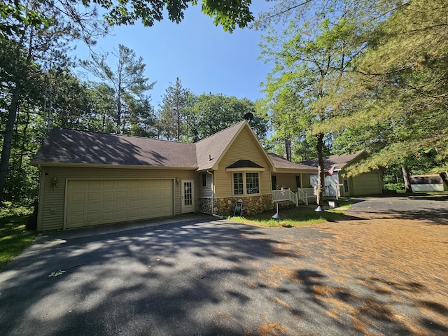 14911 Kings Ln, Ocqueoc, MI 49759 - view of front of home with driveway, stone siding, and an attached garage